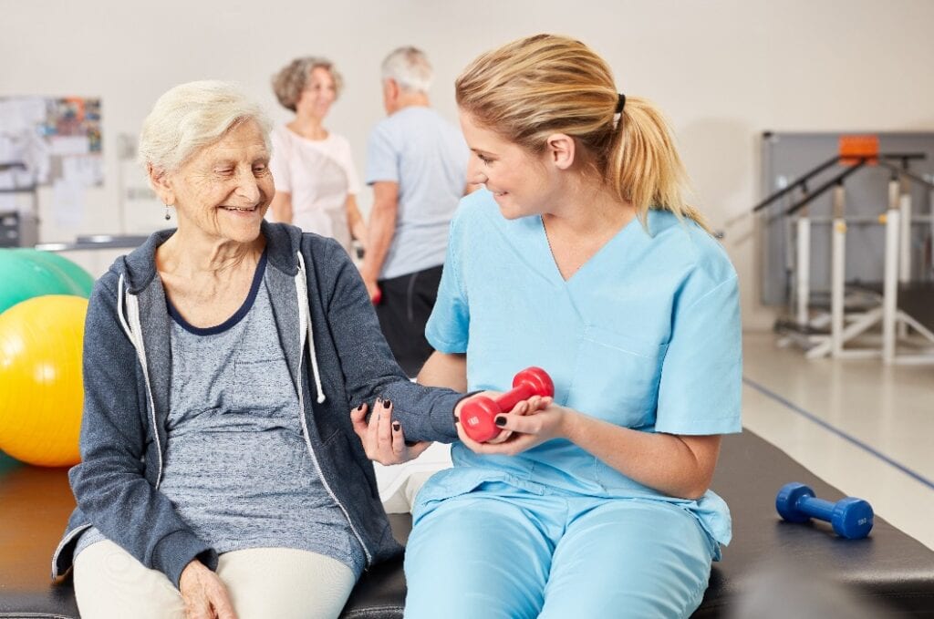 Ältere Frau beim Hanteltraining mit Therapeutin