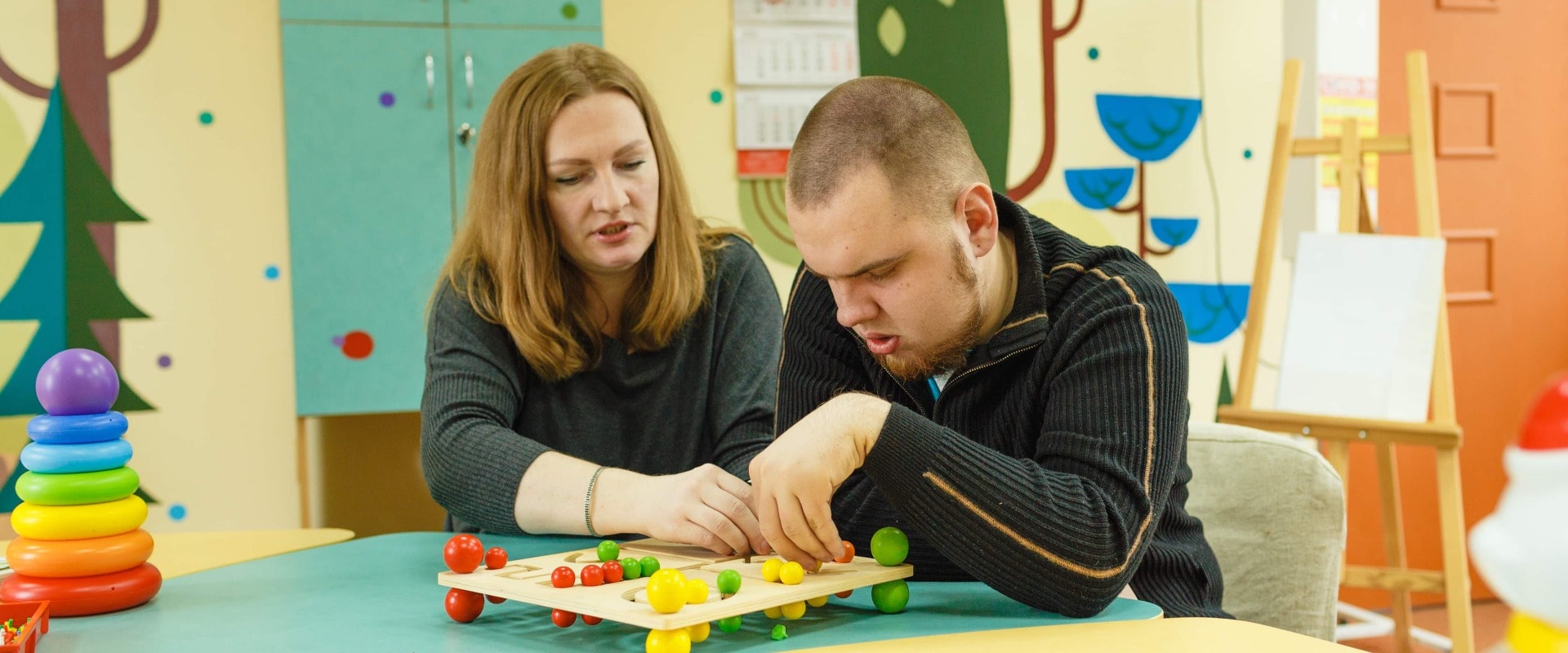 ein Psychologe beschäftigt sich mit einem autistischen Mann mit geistigen Behinderungen